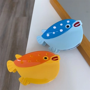 Détail de pinces à cheveux poisson-globe avec finition acétate colorée et pois