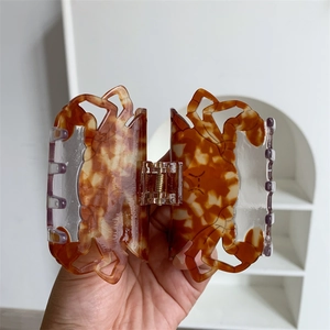 Détail de la pince à cheveux crabe ambre avec texture écaille de tortue et ressort métal