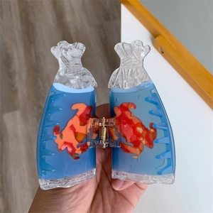 Detail showing the light blue acetate sea star hair claw clip with orange accents