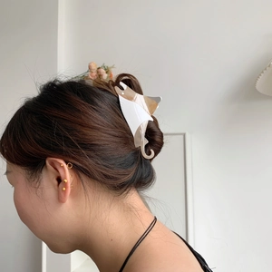 Creative stingray hair claw clip made of acetate worn on a bun hairstyle