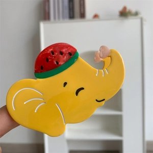 Détail de la pince à cheveux éléphant jaune avec chapeau pastèque et coeur rose