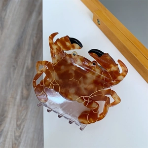 Détail de la pince à cheveux crabe avec motif écaille ambre et contours dorés fins