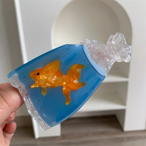 Detailed close-up of a goldfish acetate hair claw clip shaped like a water bag