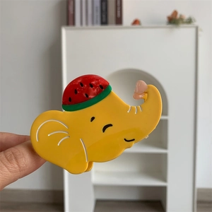 Vue détaillée d'une pince à cheveux éléphant jaune en acétate avec un motif de pastèque