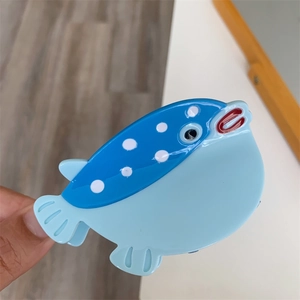 Détail de la pince à cheveux poisson en acétate avec des tons bleus et des points blancs