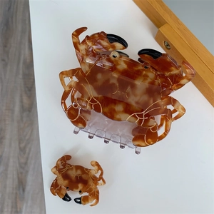 Vue détaillée des pinces à cheveux crabe en écaille avec texture ambrée et détails dorés