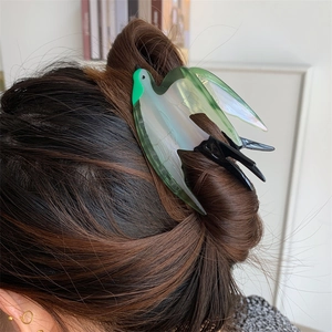 Pince à cheveux en forme d'hirondelle en acétate avec dégradé vert sur cheveux bruns