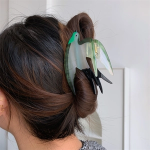 Détail de la pince à cheveux hirondelle en acétate marbré vert et blanc sur cheveux
