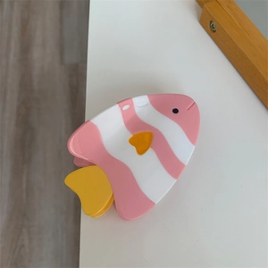 Détail de la pince à cheveux poisson rayée rose et blanche avec nageoires jaunes