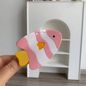 Détail de la pince à cheveux en forme de poisson rayé rose et blanc en acétate poli