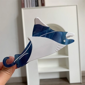 Detailed close-up of a manta ray hair claw clip in blue marbled and white acetate
