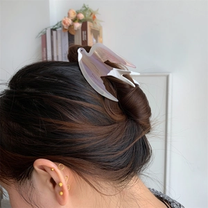 Vue détaillée d'une pince à cheveux hirondelle dégradée lavande sur un chignon