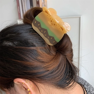 Detalle de la creativa pinza para el pelo con forma de hamburguesa en un moño bajo