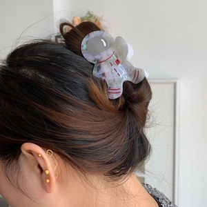 Pince à cheveux astronaute en acétate portée par un modèle pour un style créatif