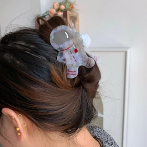 Vue détaillée de la pince à cheveux astronaute en acétate avec motif marbré bleu sur cheveux