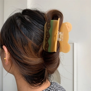 Detalle de la pinza para el pelo creativa con forma de hamburguesa y oso en acetato brillante
