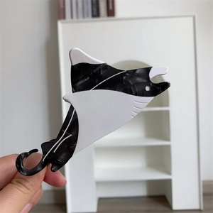 Macro detail of manta ray shaped hair claw clip with black and white marble acetate finish