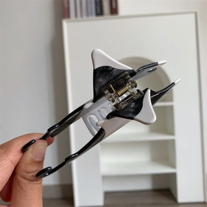 Detail view of manta ray star hair claw with black and white acetate and metal spring
