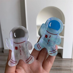 Détail des pinces à cheveux astronaute en acétate irisé bleu et blanc de haute qualité