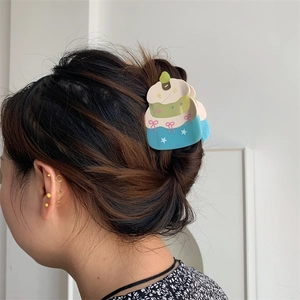 Detail view of a 3-layer cake-shaped hair claw with ribbon bow and star patterns