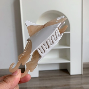 Detail view of marble acetate shark hair claw clip with bionic design and smooth texture