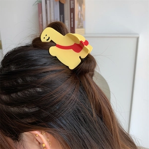 Gros plan d'une jolie pince à cheveux girafe jaune avec sac à dos sur cheveux bruns