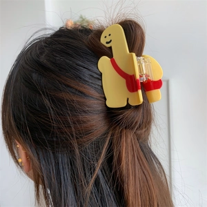 Pince à cheveux girafe jaune mignonne avec petit sac rouge portée sur les cheveux
