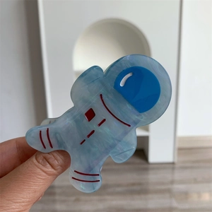 Détail de la pince à cheveux astronaute bleu glacé en acétate avec texture marbrée