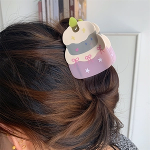 Detail of a layered acetate cake-shaped hair claw clip worn on dark brown hair