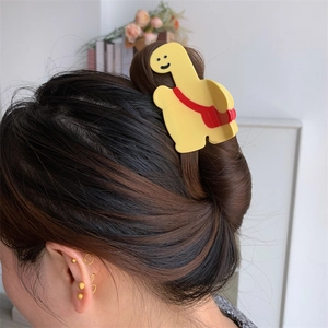 Détail d'une pince à cheveux girafe jaune mignonne avec motif de sac à dos rouge