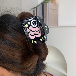Creative bear paw hair claw clip with colorful floral patterns on a stylish hair bun