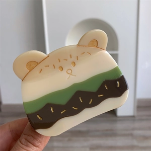 Detalle de la pinza para el pelo con forma de oso en acetato y diseño de varios colores