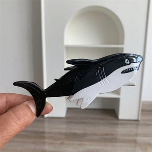 Detail of shark shaped hair claw clip showing acetate material and black white design