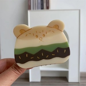 Detalle de la pinza para el pelo de oso en acetato con diseño en capas y toques dorados