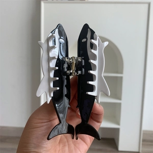 Detailed view of an orca shaped hair claw clip with black and white resin finish