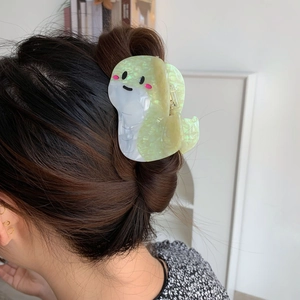 Dettaglio di una graziosa molletta per capelli in acetato verde marmorizzato a forma di serpente