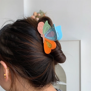 Detail der bunten Schmetterlings-Haarklammer aus Acetat mit Strass am Haar