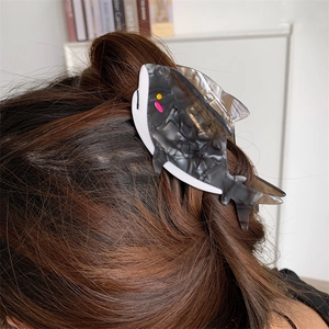 Dettaglio della molletta per capelli a forma di squalo marmorizzato grigio in acetato