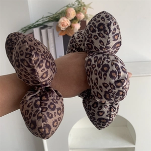 Detail of a large leopard print velvet scrunchie worn on a wrist for a stylish look