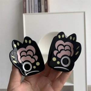 Detail shot of creative bear paw hair claw clips featuring pink and cream color block design