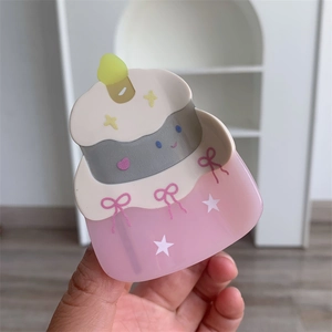 Detail of pink acetate birthday cake hair claw clip with white star patterns and bow