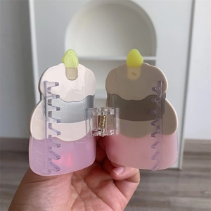 Close-up of a creative cake bottle shaped acetate hair claw clip with bow and spring detail