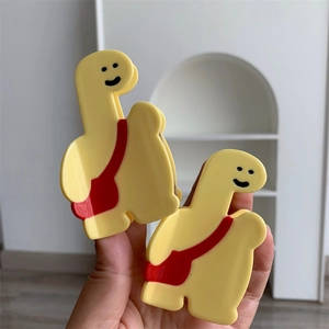 Gros plan de pinces à cheveux dinosaure jaune avec détails de sac rouge poli