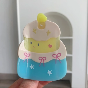 Detail of blue and white acetate cake hair claw clip with pink bows and a smiling face