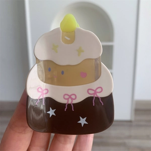 Detailed close-up of a birthday cake hair claw clip with bow and candle details