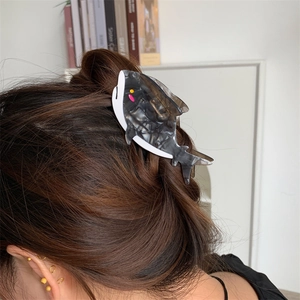 Pinza per capelli a forma di balena in acetato con trama marmorea sui capelli