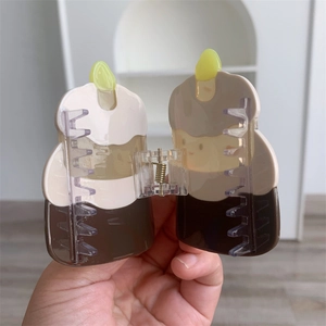 Close-up of birthday cake shaped acetate hair claw with cream and brown splicing detail