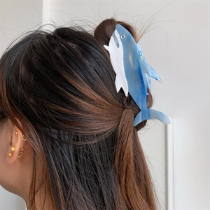 Detailed view of a shark-shaped blue and white marble acetate hair claw clip for women