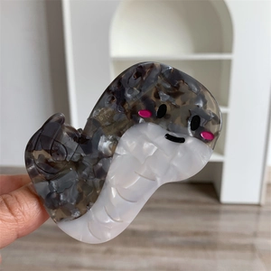 Dettaglio del fermaglio per capelli a forma di serpente in acetato con trama marmorizzata