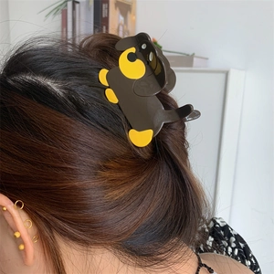 Detail of dachshund hair claw clip in dark brown and yellow on wavy long hair
